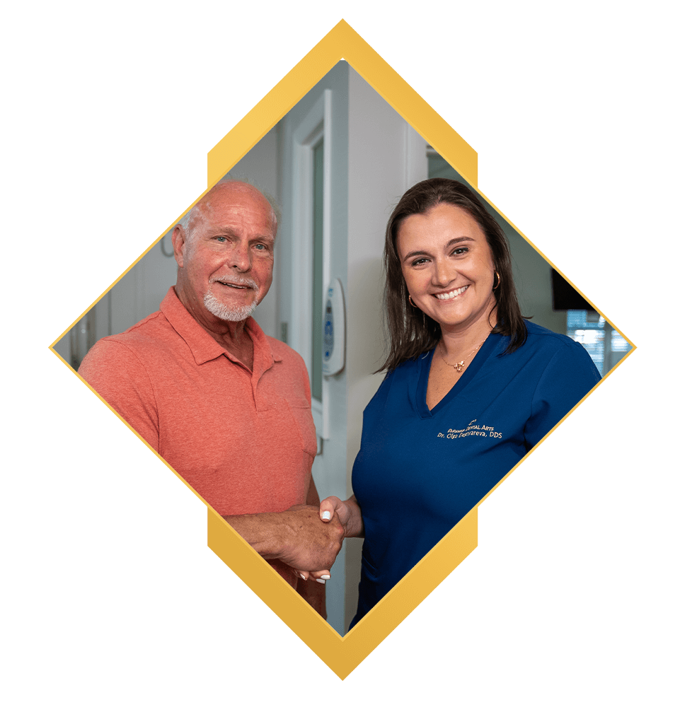 doctor and patient shaking hands and smiling brightly after dental procedure